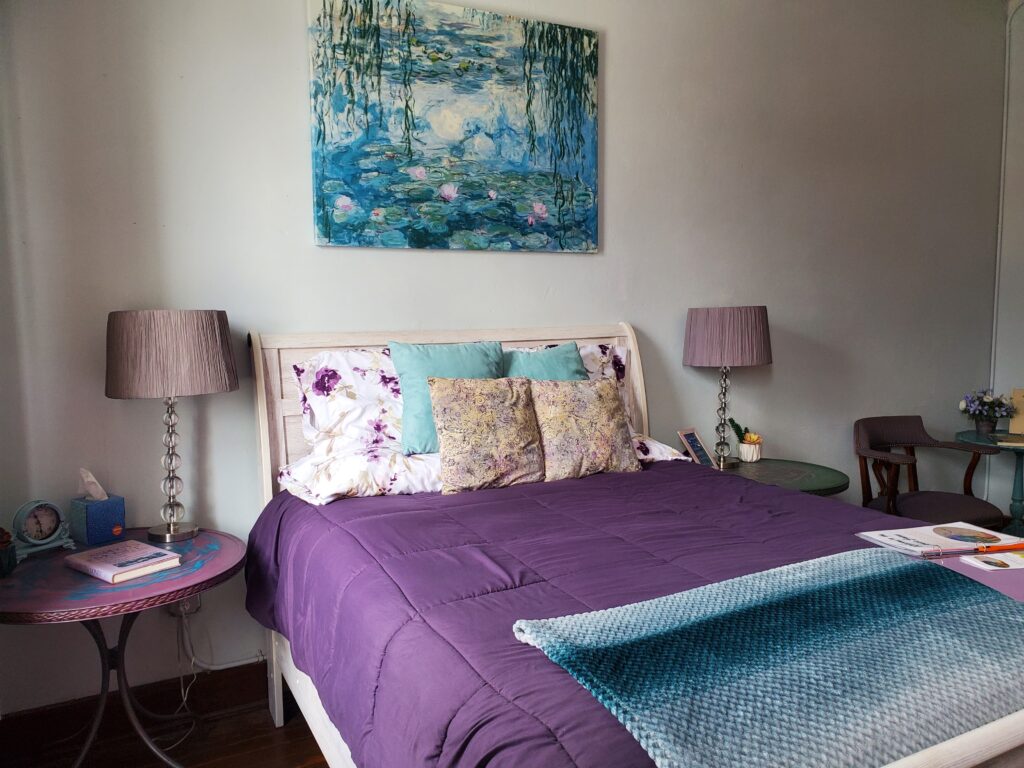 Monet room with purple comforter and blue blanket